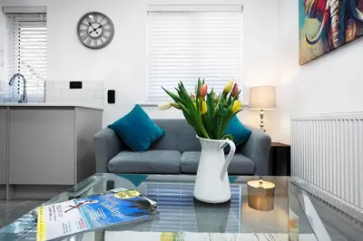 a living room with a couch and a vase with flowers at Lucas in Sudbury