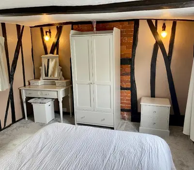 a bedroom with a white cabinet and a desk at Chelmsford Cottage Free Parking Fab Garden in Great Waltham