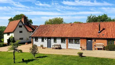 a large white house with a red roof at Packway Barn in Halesworth
