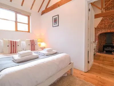a bedroom with a bed with two pillows on it at Packway Barn in Halesworth