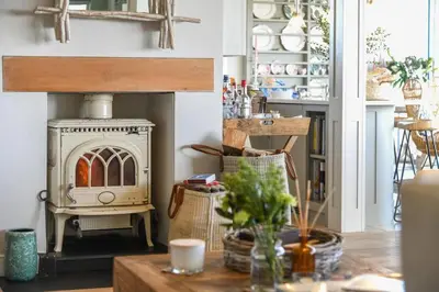 a living room with a stove and a table at Spinneys Beachfront home, Indoor Pool UK-Vacations in Thorpeness