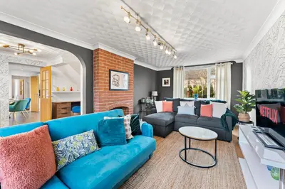 a living room with a blue couch and a table at Boutique Cambridgeshire Gem in Fulbourn