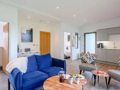 a living room with a blue couch and a table at 2 Bed in Colchester oc-82398 in East Bergholt