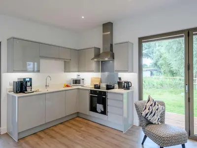 a kitchen with white cabinets and a large window at 2 Bed in Colchester oc-82398 in East Bergholt