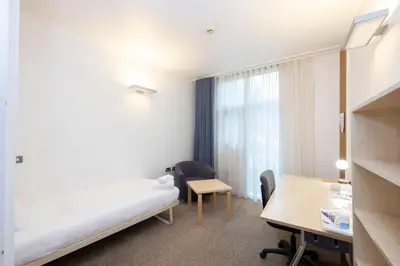 a hotel room with a bed and a desk at Stephen Hawking Building Gonville and Caius College in Cambridge