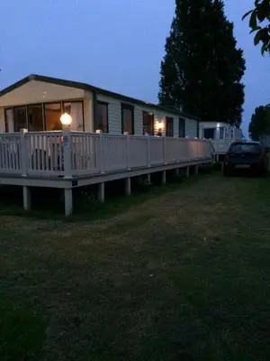 a house with a porch and a car parked in front of it at Lazeeedays on Mersea Island in Colchester