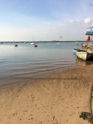 a boat sitting on the shore of a beach at Lazeeedays on Mersea Island in Colchester