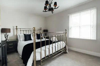 a bedroom with a black and white bed and a window at Fun house in the heart of Colchester in Colchester
