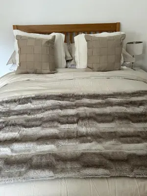 a bed with a gray blanket and pillows at Stylish house centrally located in Bury Saint Edmunds