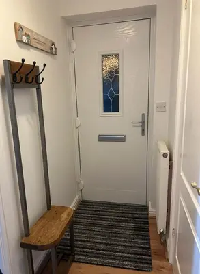 a hallway with a white door and a wooden chair at Stylish house centrally located in Bury Saint Edmunds