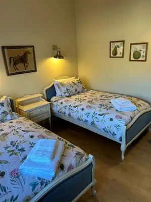 a bedroom with two beds and two tables in it at A family and dog friendly haven, The Hayloft. in Saxmundham