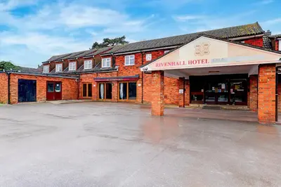an empty parking lot in front of a brick building at The Rivenhall Hotel in Witham, Chelmsford in Witham