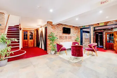 a room with a table and chairs and a brick wall at The Rivenhall Hotel in Witham, Chelmsford in Witham