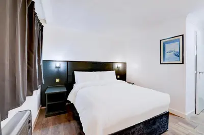 a bedroom with a large white bed and a window at The Rivenhall Hotel in Witham, Chelmsford in Witham
