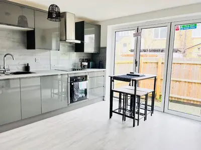 a kitchen with two bar stools and a counter at Stylish Cambridge Apartment with Garden in Cambridge