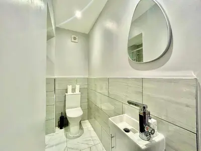 a white bathroom with a toilet and a mirror at 6 Bedroom House - DISC0UNTS - Parking, Contractors, Group, Family in Ipswich