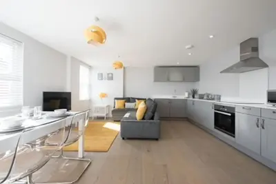 a kitchen and living room with a couch and a table at Beautiful, Spacious 1 bed flat in Brentwood