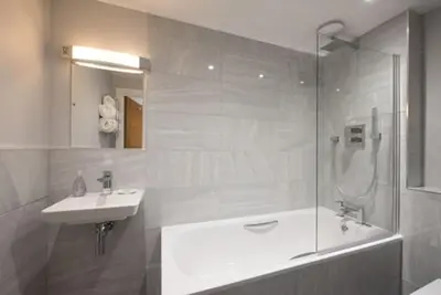a bathroom with a tub and a sink and a shower at Beautiful, Spacious 1 bed flat in Brentwood