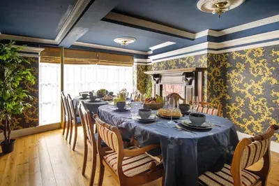 a dining room with a long table and chairs at The Famous Harry Potter House, Hot Tub, Cinema Room, Sky TV in Saffron Walden