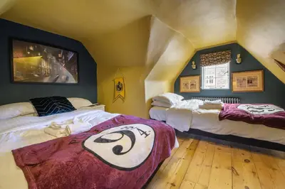 a bedroom with two beds in a room with an attic at The Famous Harry Potter House, Hot Tub, Cinema Room, Sky TV in Saffron Walden