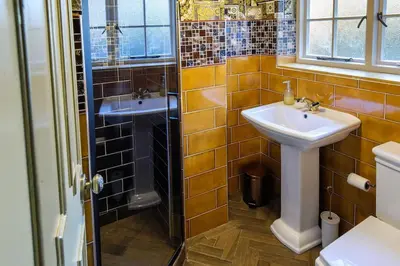 a bathroom with a sink and a shower at Luxury 2 Bed Manor House With Hot Tub, Cinema Room, Sky TV in Saffron Walden
