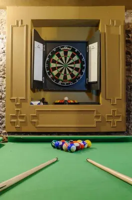 a dart board and some balls on a pool table at Luxury 2 Bed Manor House With Hot Tub, Cinema Room, Sky TV in Saffron Walden