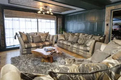 a living room with couches and a coffee table at Luxury 2 Bed Manor House With Hot Tub, Cinema Room, Sky TV in Saffron Walden