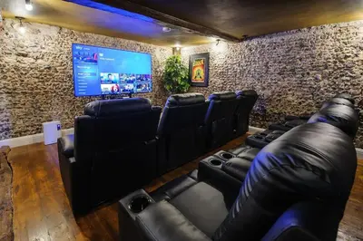a room with black leather chairs and a flat screen tv at Luxury 3 Bed Manor House With Hot Tub, Cinema Room, Sky TV in Saffron Walden