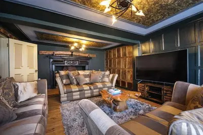 a living room with couches and a flat screen tv at Luxury 3 Bed Manor House With Hot Tub, Cinema Room, Sky TV in Saffron Walden