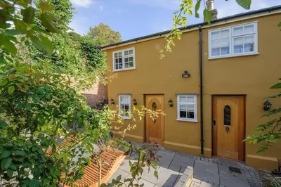 a large yellow house with a wooden door at Luxury 3 Bed Manor House With Hot Tub, Cinema Room, Sky TV in Saffron Walden