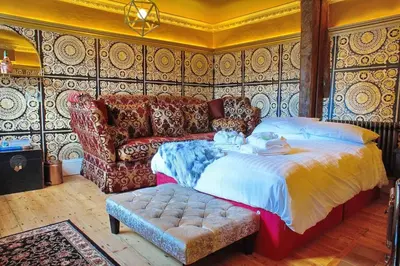 a bedroom with a bed and a couch at Luxury 3 Bed Manor House With Hot Tub, Cinema Room, Sky TV in Saffron Walden