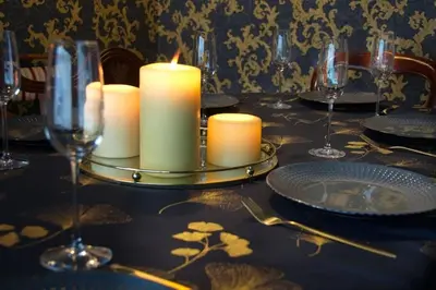 a table with candles and plates and wine glasses at Luxury 3 Bed Manor House With Hot Tub, Cinema Room, Sky TV in Saffron Walden