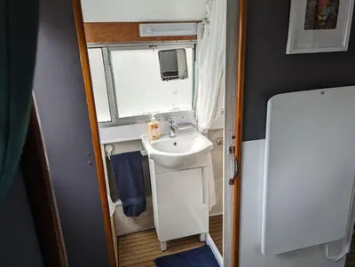 a small bathroom with a sink and a window at New Horizon - A beautiful boat very conveniently located in Chelmsford City in Chelmsford
