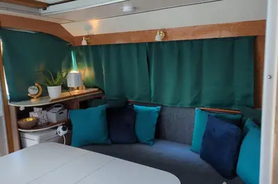 a bedroom with a couch and blue pillows at New Horizon - A beautiful boat very conveniently located in Chelmsford City in Chelmsford