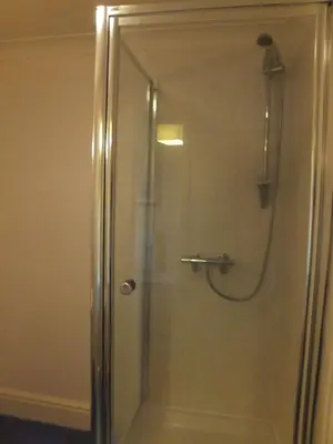 a shower with a glass door in a bathroom at The Red Lion, Stretham in Ely