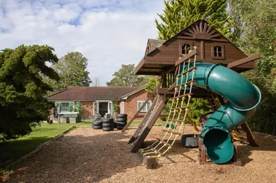 a playground with a slide and a house at Deluxe 2 Bed Versace HotTub SkyTV in Saffron Walden