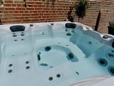 a jacuzzi tub in front of a brick wall at Executive Suite with Private Hot Tub SkyTV in Saffron Walden