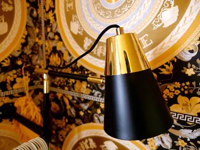 a black and gold lamp hanging on a wall at Deluxe 2 3 Bed HotTub SkyTV in Saffron Walden