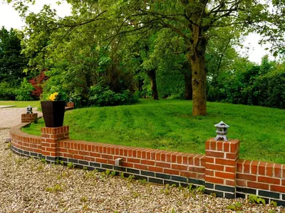 a brick wall with a vase in a park at Deluxe 1 Bed Versace HotTub SkyTV in Saffron Walden