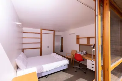 a bedroom with a bed and a desk with a computer at Harvey Court Gonville and Caius College in Cambridge