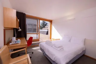 a bedroom with a bed and a desk and a window at Harvey Court Gonville and Caius College in Cambridge