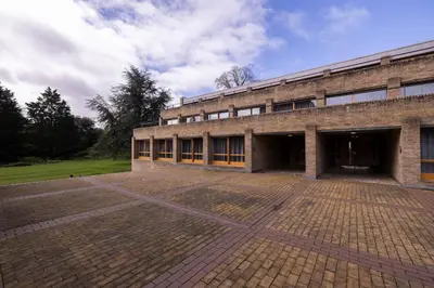 a brick building with a large courtyard in front of it at Harvey Court Gonville and Caius College in Cambridge