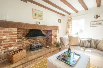 a living room with a couch and a fireplace at Harvest Cottage in Aldeburgh