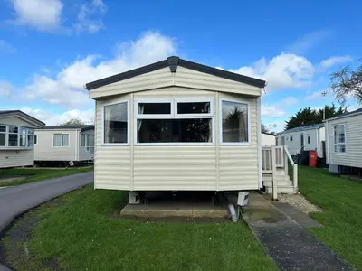 a tiny house sitting on the grass in a yard at D34 Steeple Bay Caravan Site in Chelmsford