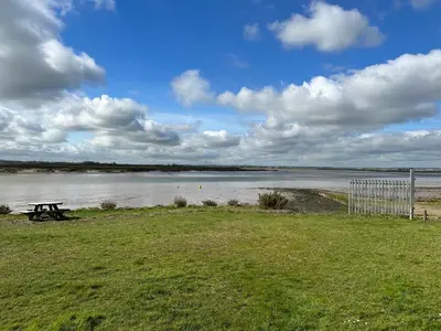 a picnic table next to a body of water at D34 Steeple Bay Caravan Site in Chelmsford