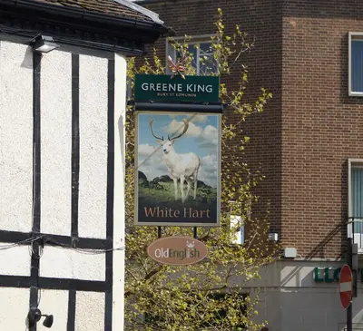 a sign for a white hunt on the side of a building at White Hart Hotel by Greene King Inns in Braintree