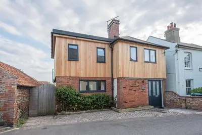 a wooden house with a brick at Melody Cottage in Aldeburgh
