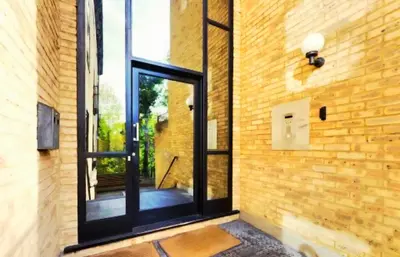 a room with a glass door on a brick wall at Urban Oasis in Billericay