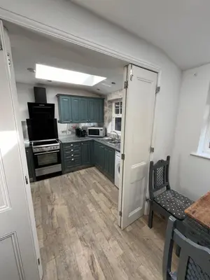 a kitchen with green cabinets and a stove top oven at Seagull studio in Felixstowe