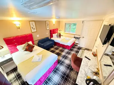 a hotel room with two beds and a couch at 4 Sisters Inn in Theydon Bois